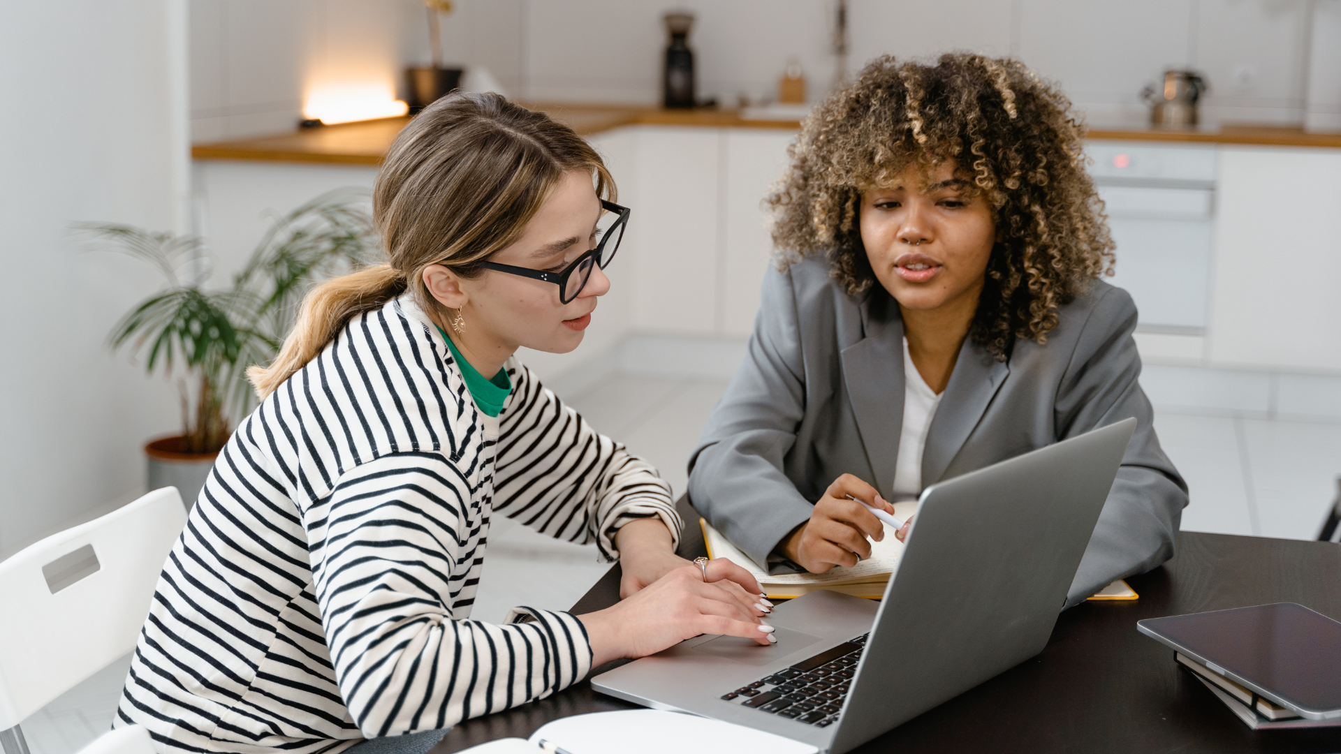 A client and a learning experience design consultant look at a computer together.